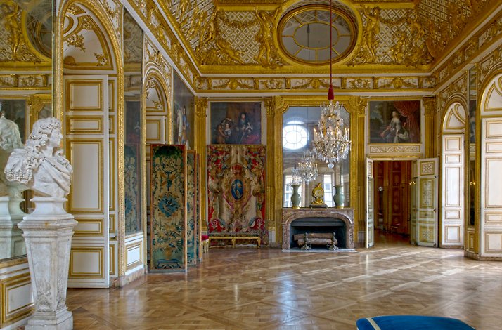 One of the beautiful rooms of the Château de Versailles with a statue and images on the walls.