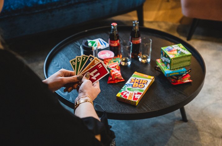 A woman playing table game Skip-Bo sitting at hotel Savarin