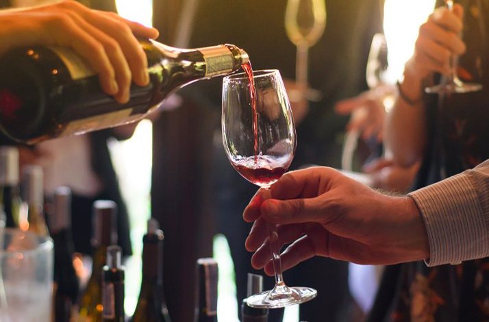 A group of people sampling various wines at the Hotel Donna Camilla Savelli.