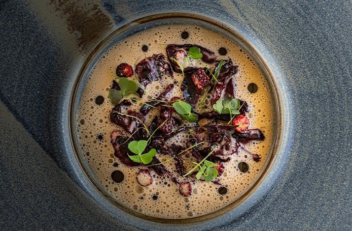 A bowl of salad with greens made by the chef of restaurant PRU
