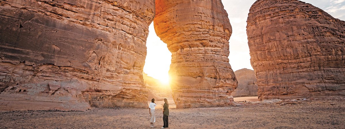 Two people exploring AlUla, an oasis city located in the northwestern Hejaz region.