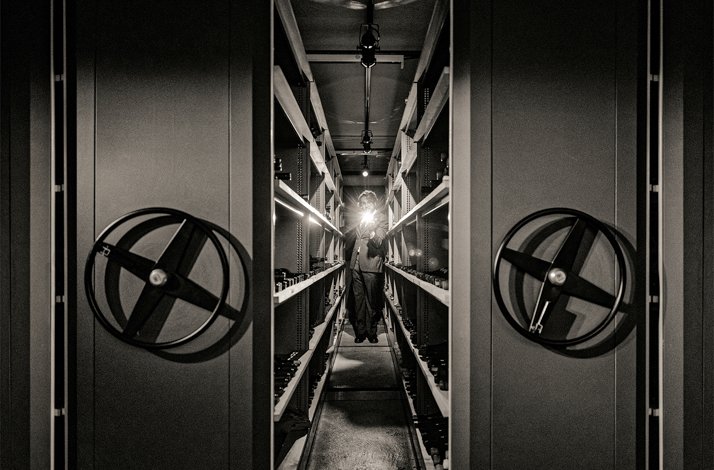 Enter PM & Vänner's wine vault for a one-of-a-kind tasting experience: In Växjö, Sweden Chef is shining a flashlight at sliding movable shelves of exceptional wines housed in the cool, wood-scented vault at PM & Vänner Restaurant.
