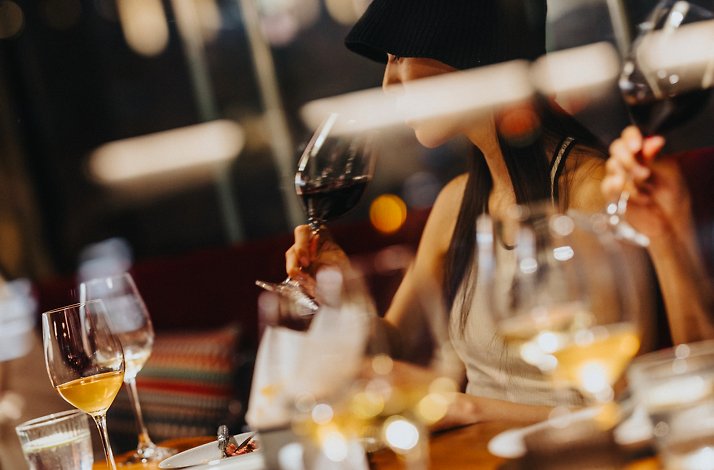 Young woman drinking red wine at the MONA restaurant, Shanghai, China.