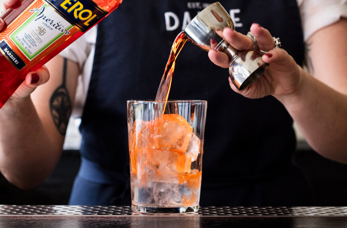 A person mixing a cocktail at a hands-on cocktail making class in Dante NYC.