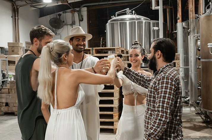 A group of persons inside of Tulum Beer fabric, enjoying a pints