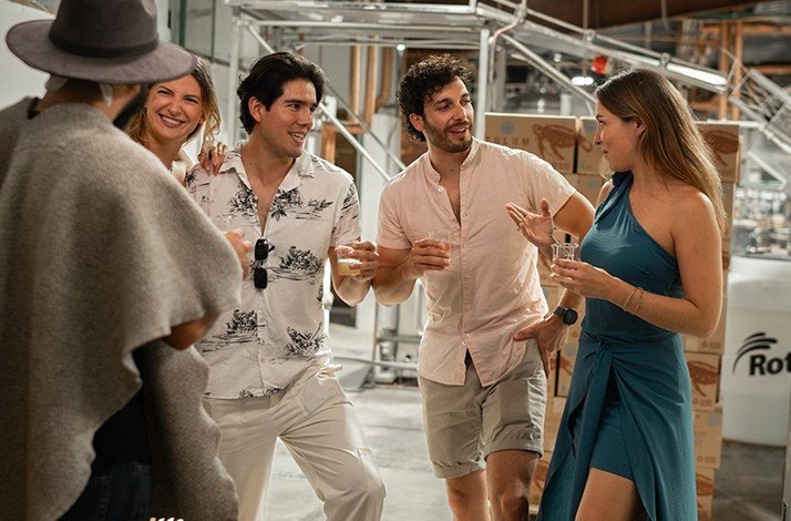 A group of persons inside of Tulum Beer fabric, enjoying a pints