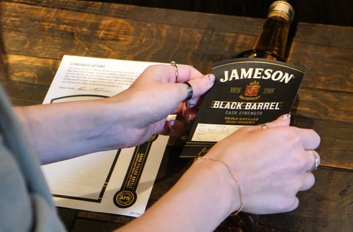 A woman holds a bottle of Jameson whiskey at the Midleton Distillery.