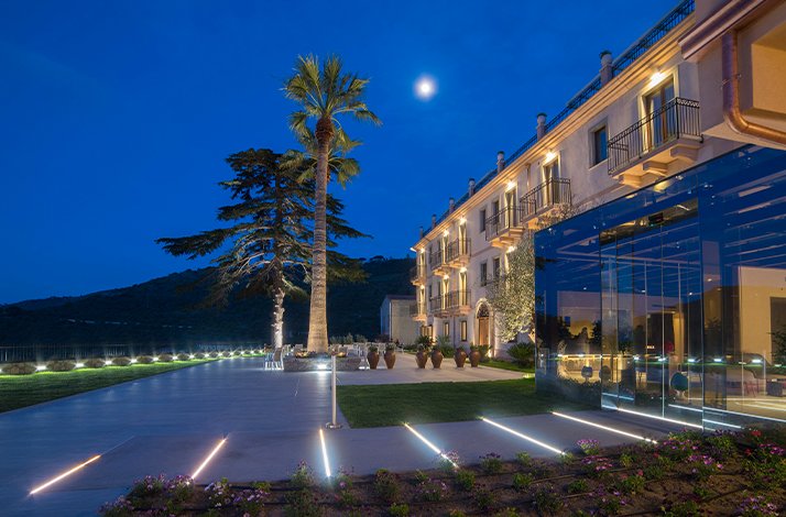 Outside view of a large luxurious hotel at dusk showing the hotel's light display