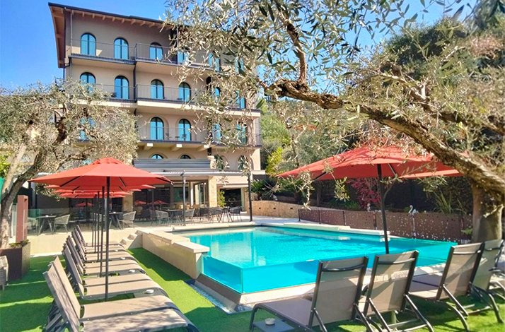 An outdoor private pool with beach lounge chairs and umbrellas