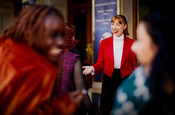 Red Coat concierge greeting the guests at London's Cambridge Theatre.