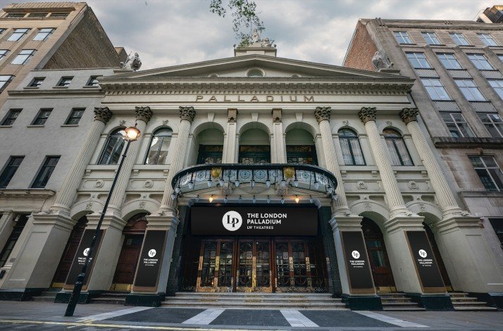 Front entrance of London Palladium theater, showcasing it's classical design with columns, arches, and ornate details.