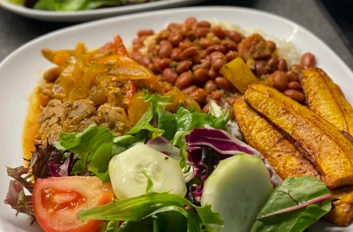 Puerto Rican dish on a white plate with vegetables.