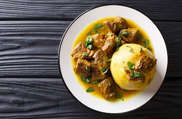 Puerto Rican mofongo made from plantains, garlic and chicharron served with meat and broth