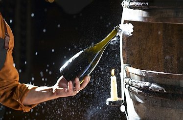 A waiter opening a bottle of wine produced at a historic Franciacorta winery