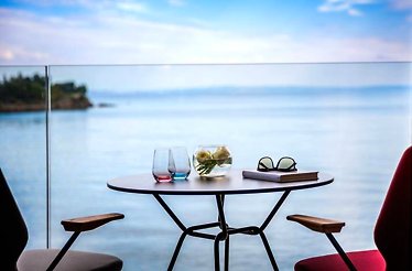 A table and two chairs on the Hotel Navis terrace with a view on Kvarner Bay.
