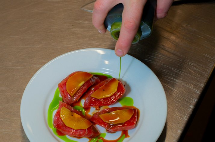 The chef dresses the appetizing dish with sauce at Ritmo, the Michelin-starred Arkestra.