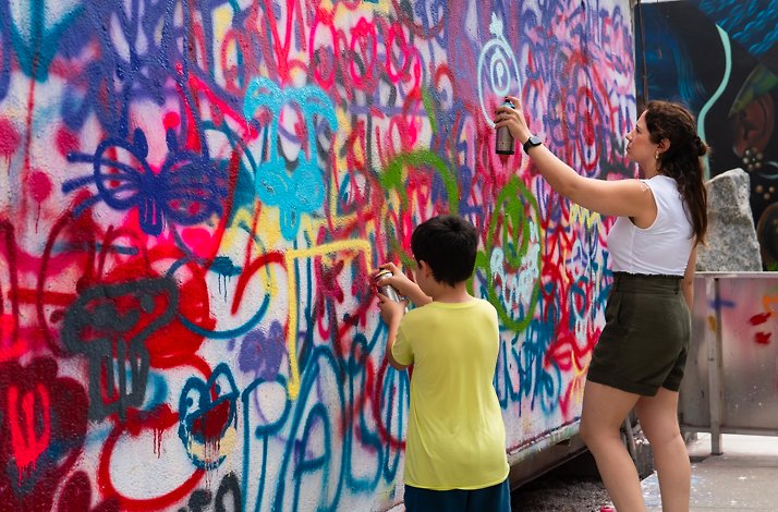 Two people spraying on the street art museum Wynwood Walls.