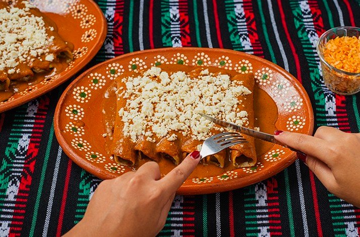 A person is tasting a Mexican dish.