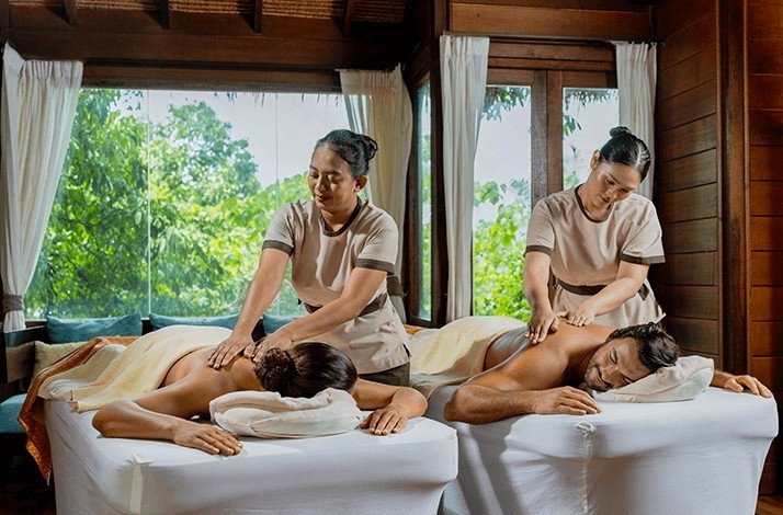Two individuals receiving massages in a serene room, surrounded by calming decor and soft lighting.