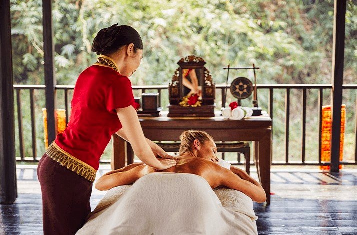 A woman receiving a relaxing massage in a serene spa environment, surrounded by calming decor and soft lighting.