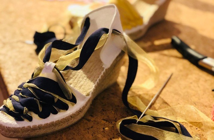 A handcrafted black and golden striped espadrilles on heels.