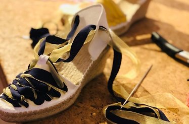 A handcrafted black and golden striped espadrilles on heels.