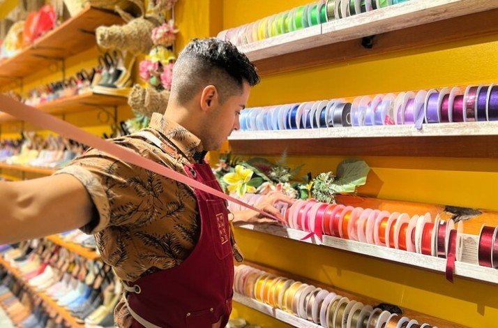 Shoemaker choosing satin ribbon for handmade shoes.