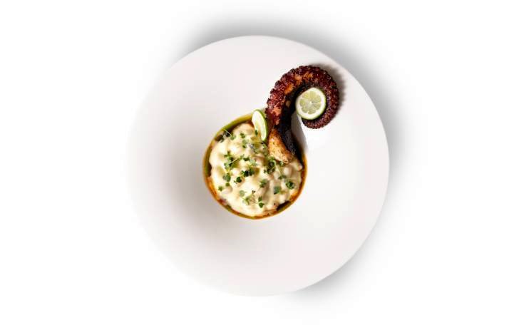 A white plate filled with a colorful assortment of food items made by the Lemongarden Restaurant