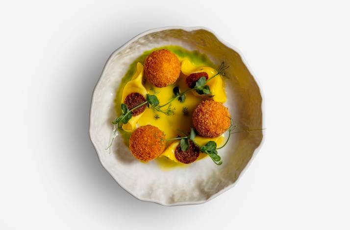 A white plate filled with a colorful assortment of food items made by the Lemongarden Restaurant