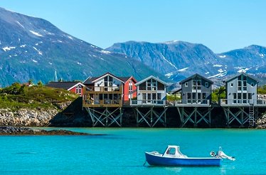 Cottages at the shore of a lake in Norway's Arctic landscapes.
