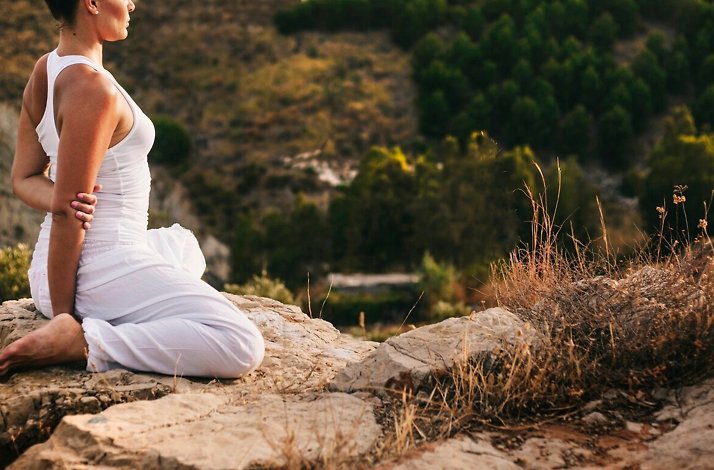 A woman practicing yoga on Philopappos Hill in Athens, Greece.