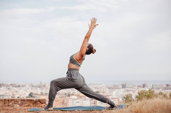 A woman practicing yoga on Philopappos Hill in Athens, Greece.