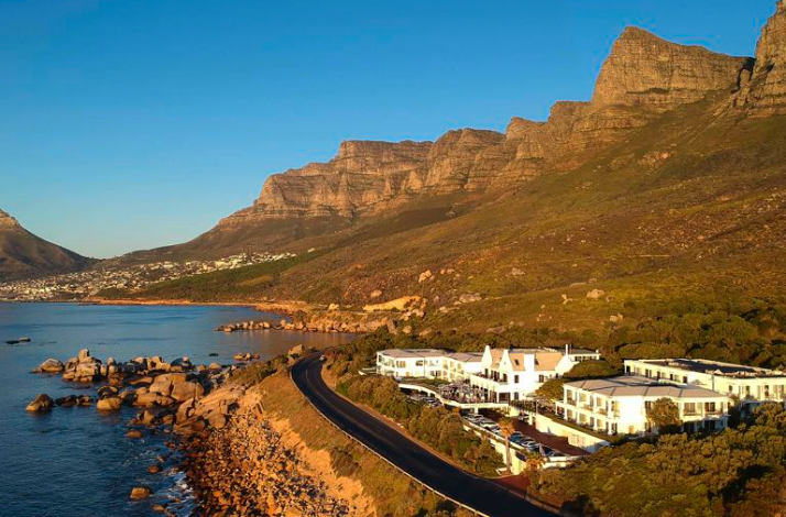 Aerial view of The Twelve Apostles Hotel and Spa nestled between the Twelve Apostles mountain range and the Atlantic Ocean in Cape Town.