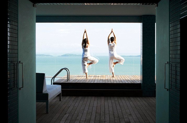 A couple practicing yoga at Como Point Yamu.