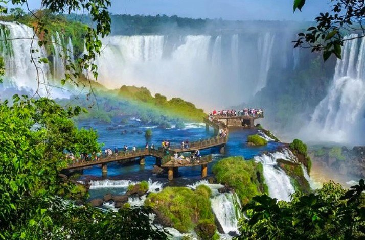 Tourists overlooking Iguazu Falls from a bridge