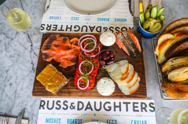 A spread of bread, cheese, and assorted foods displayed on a table at Russ & Daughters Cafe