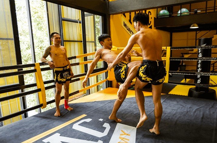 Fighters practice knee strikes in the corner of the FITFAC Muay Thai Academy.