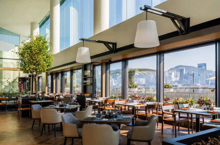 Bright restaurant interior with large windows and city views.