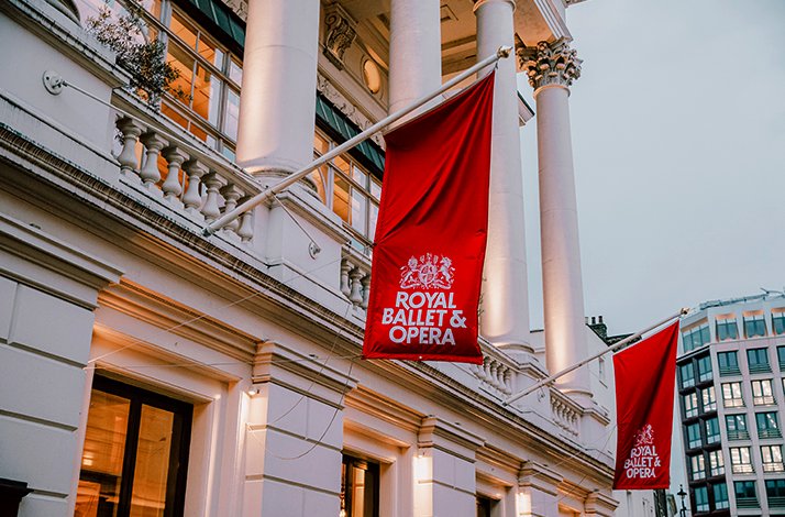 Exterior of the Royal Ballet & Opera house with red branded flags.