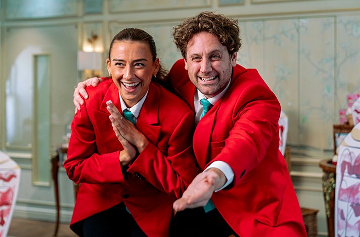 Two smiling Fortnum & Mason storytellers posing in the Diamond Jubilee Tea Salon.