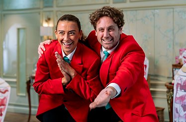 Two smiling Fortnum & Mason storytellers posing in the Diamond Jubilee Tea Salon.