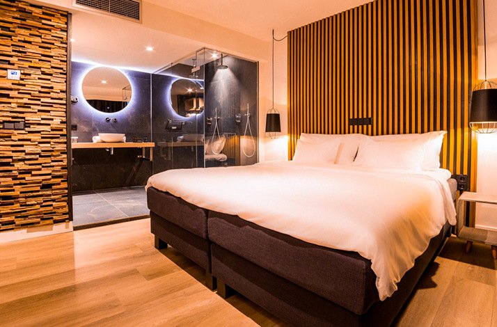 An image of the interior of a king-sized bed hotel room beside a shower room at Hotel de Sterrenberg