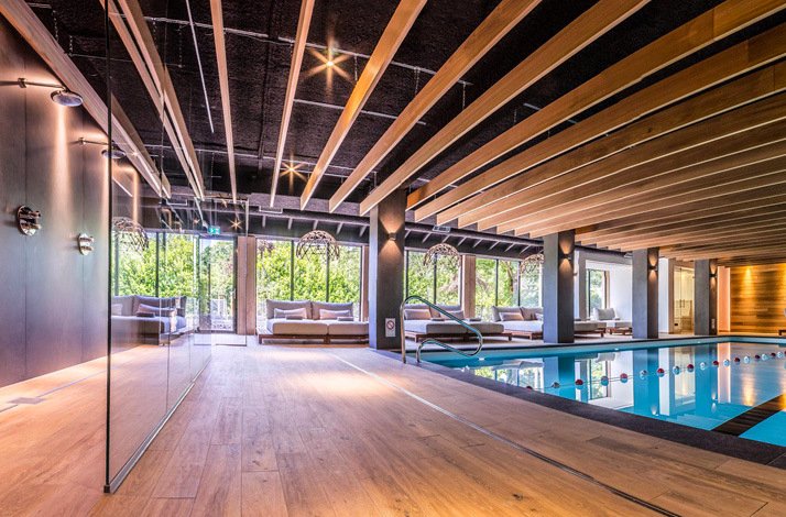 An image of a swimming pool room, equipped with guest sofas and several shower area at Hotel de Sterrenberg