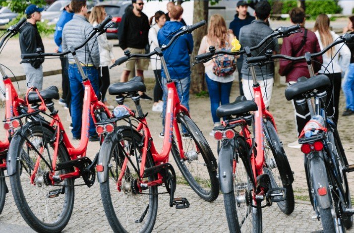 Bikes parked in line on the frontline. Participants of Secrets of Berlin Bike Tour listening to the guide at the backend.