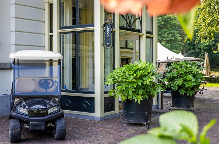 Golfcar standing next to the entrance to kasteel de vanenburg 