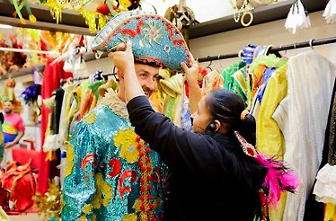 A man happily tries on authentic costumes used in previous celebrations at Rio's Carnival.