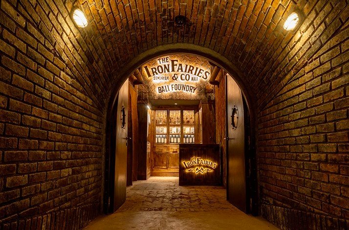 Open entrance to The Iron Fairies Bali showing lighting, brick walls and double doors.