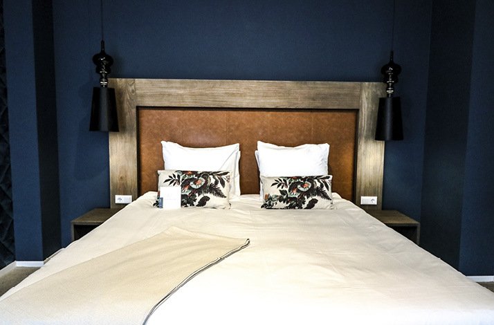 Elegant king-sized bed with plush pillows and sleek lighting in a stylish room