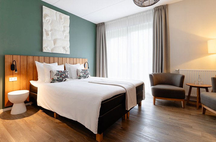 Modern bedroom with a minimalistic design, warm wood accents, and natural light.