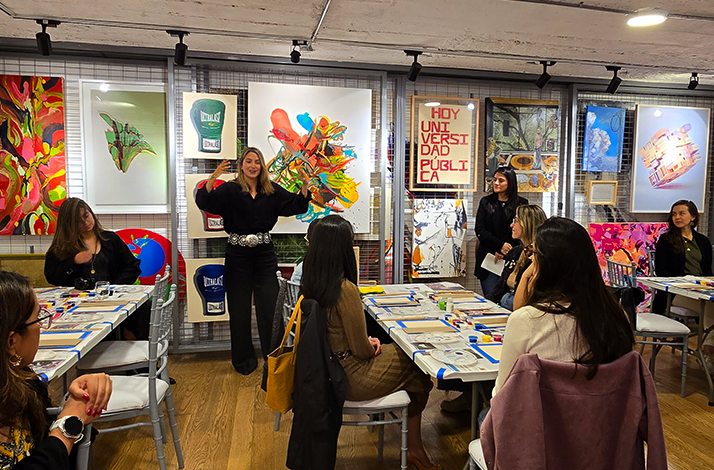 Art workshop with attendees seated, vibrant paintings, posters, and creative tools displayed around the room